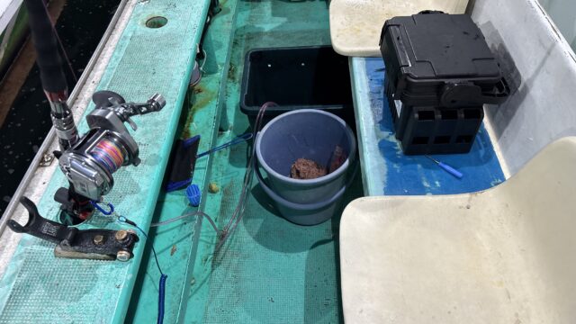 名田屋ノマセ便の釣り座にある竿受け、足元の生け簀、餌バケツと座席